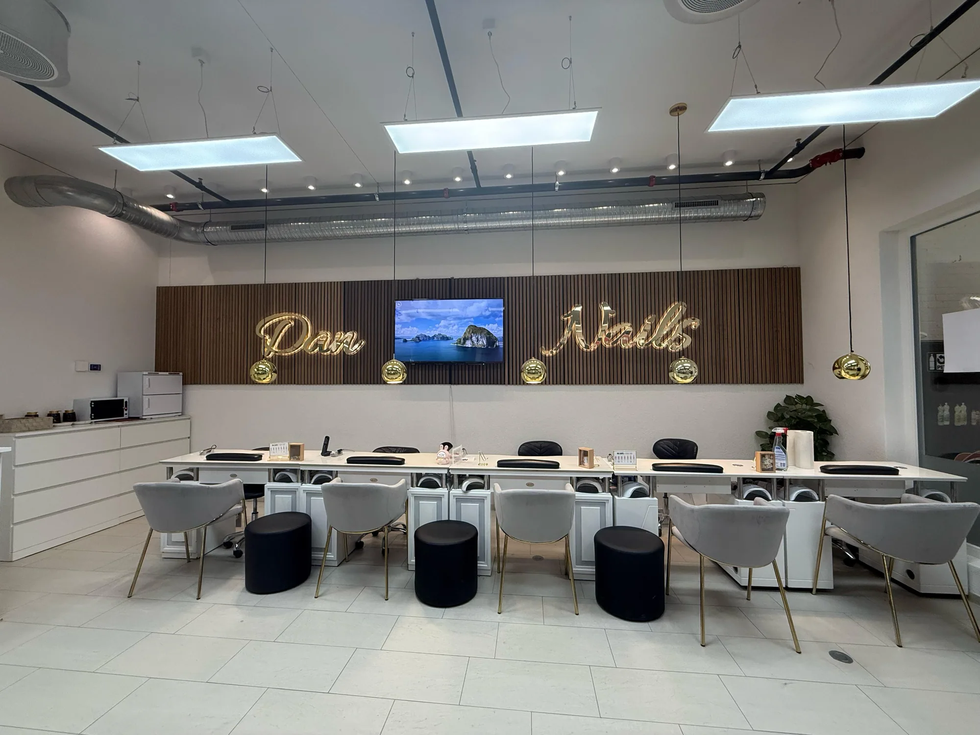 Heller Salon von Dan Nails & Beauty mit langer Reihe von Maniküre-Plätzen